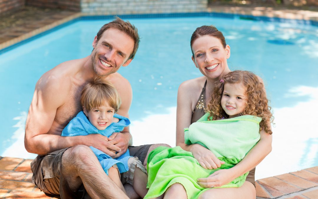 Portrait of a happy family beside the swimming pool